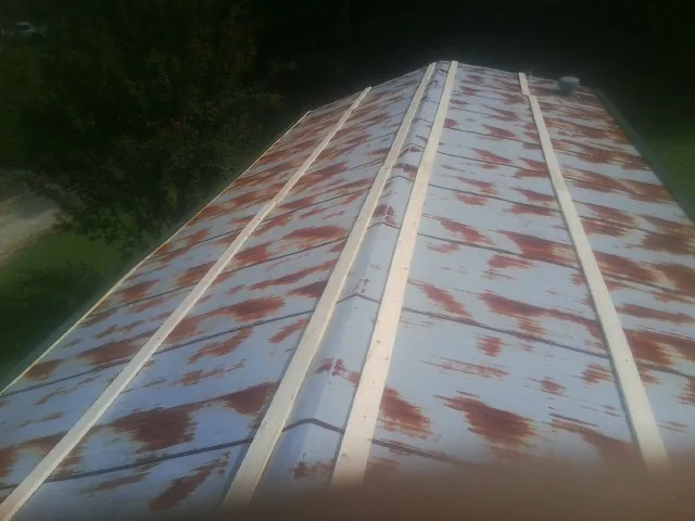 Rusted metal roof panels with new wood purlins before replacement — Storm Damage Roof Repair in Brandamore by Roofing Brothers