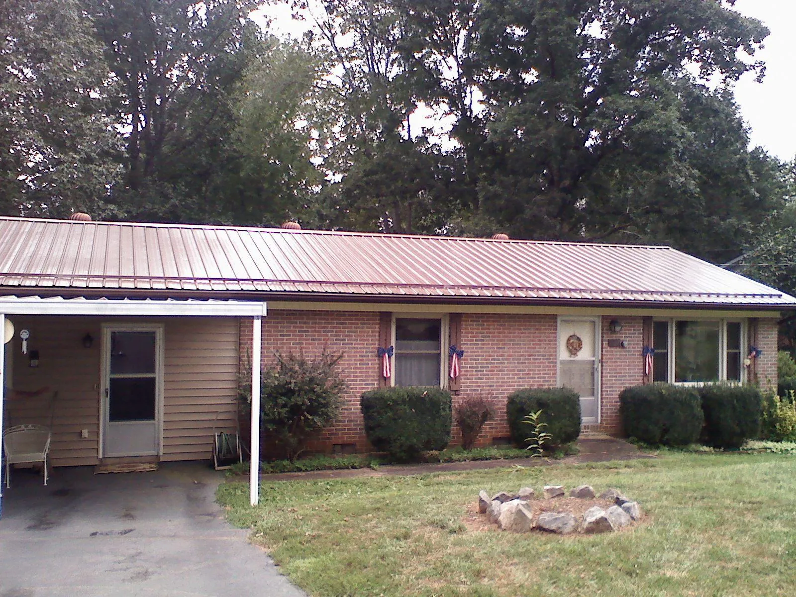 Bronze metal roof and carport on a brick ranch home — Roof Repair work by our crew in Brandamore